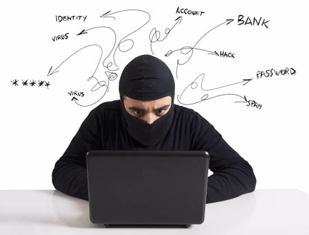 Masked person at a laptop with handwritten words like virus, bank, password and spam around the head