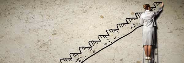 Woman on a ladder drawing a staircase on a concrete wall