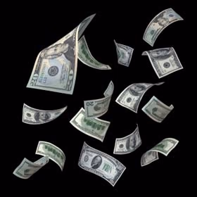 Dollar bills floating through the air against a black background