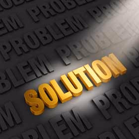 The word "Solution" in gold letters lit by a spotlight among dark letters spelling "Problem"