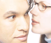 A woman whispering into a man's ear